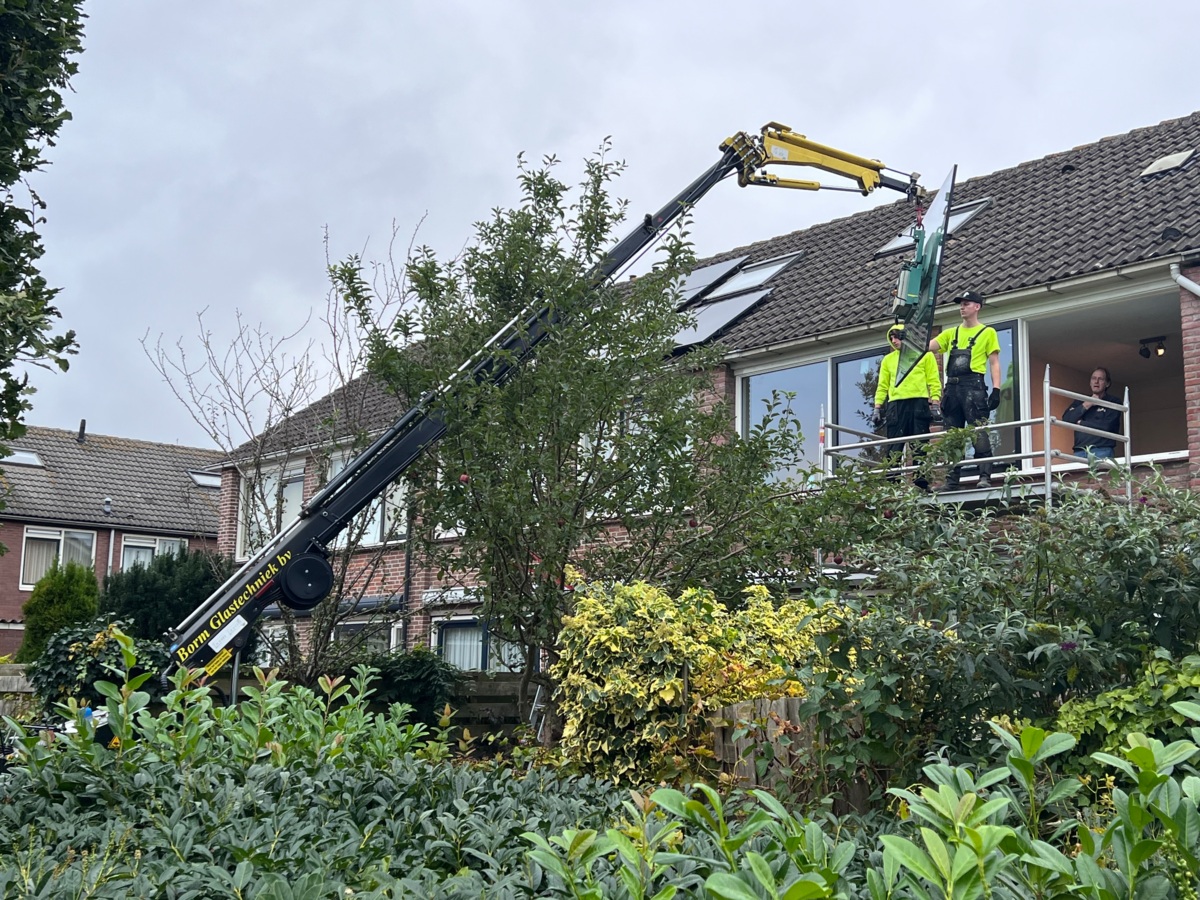 Isolatieglas wordt met een glaskraan op de bouwplaats gehesen